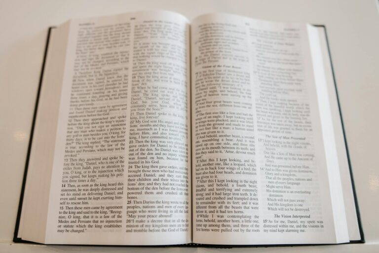 An open Holy Bible on a wooden table, showcasing scripture text, ideal for religious and spiritual themes.